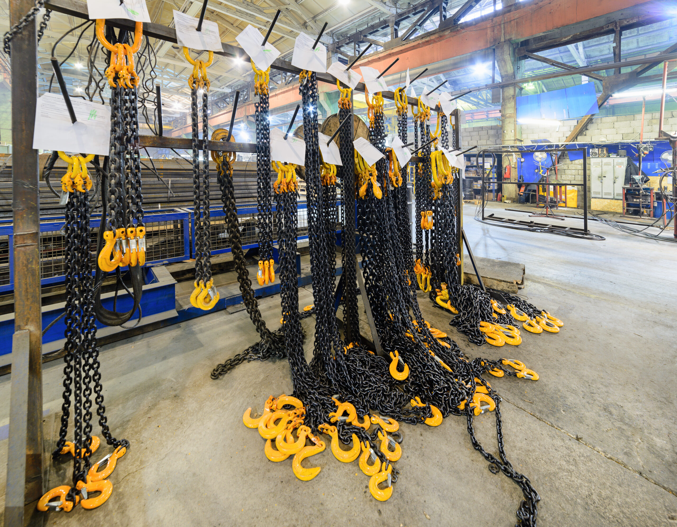 Warehouse of finished products of the enterprise for the production of handling removable devices. Rack with new cargo chain slings.